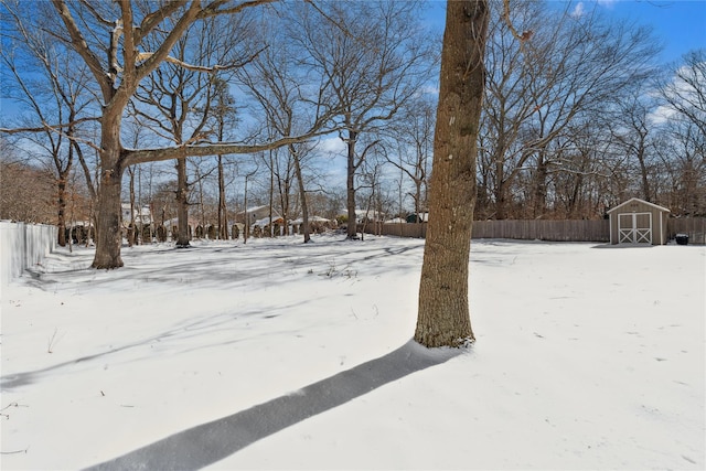 yard covered in snow with a storage shed