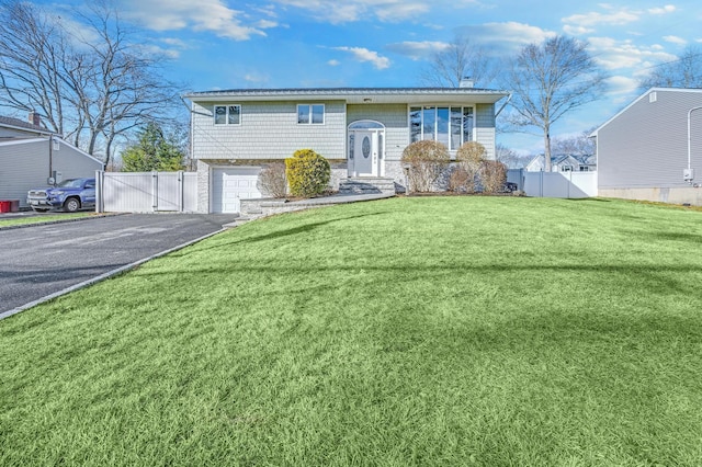 split foyer home featuring a garage and a front lawn