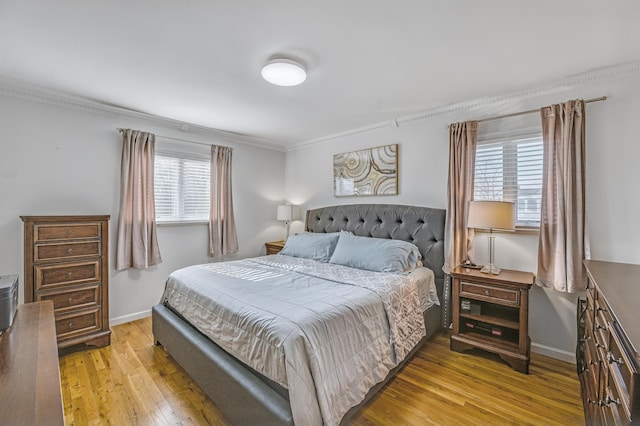 bedroom with multiple windows, crown molding, and light hardwood / wood-style floors