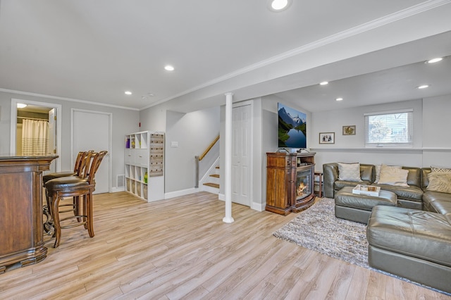 living room with crown molding and light wood-type flooring