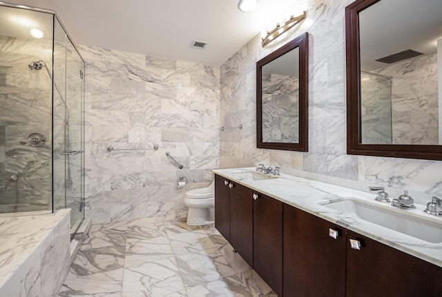 bathroom featuring vanity, a shower with shower door, toilet, and tile walls