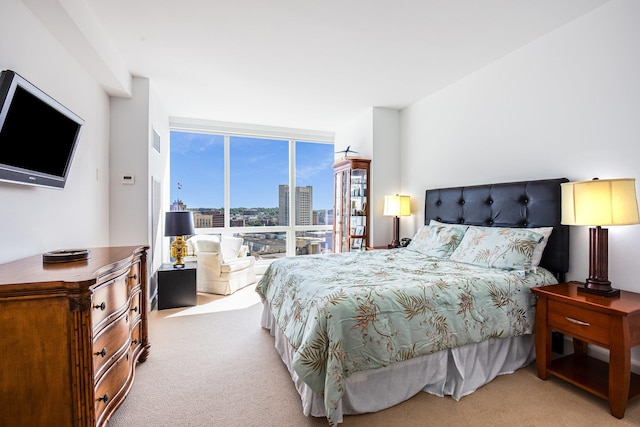 bedroom featuring light colored carpet and floor to ceiling windows