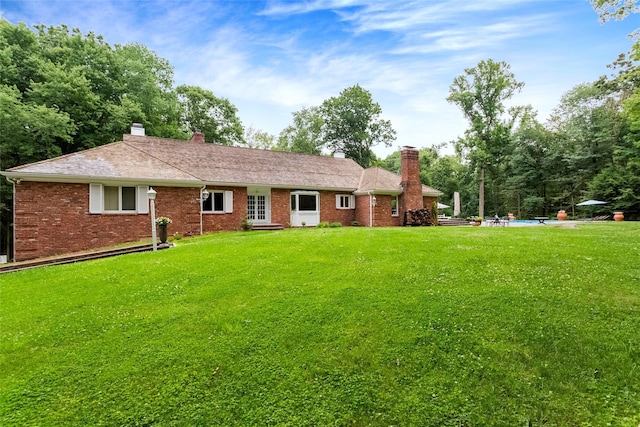 rear view of property with a yard