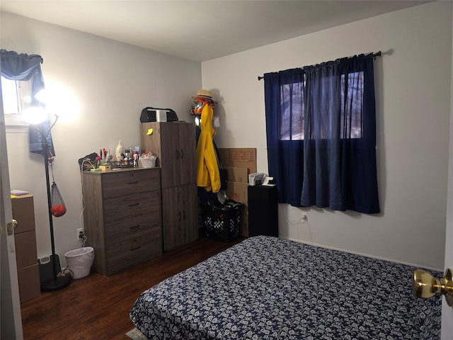 bedroom with dark hardwood / wood-style floors