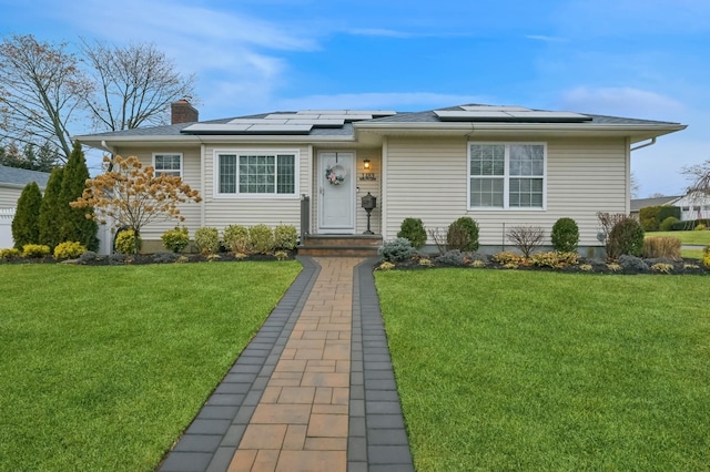 view of front facade with a front lawn and solar panels