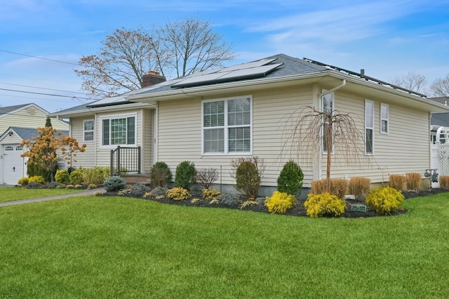 view of side of home with a lawn and solar panels