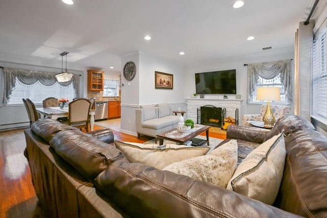 living room with a brick fireplace and light hardwood / wood-style flooring