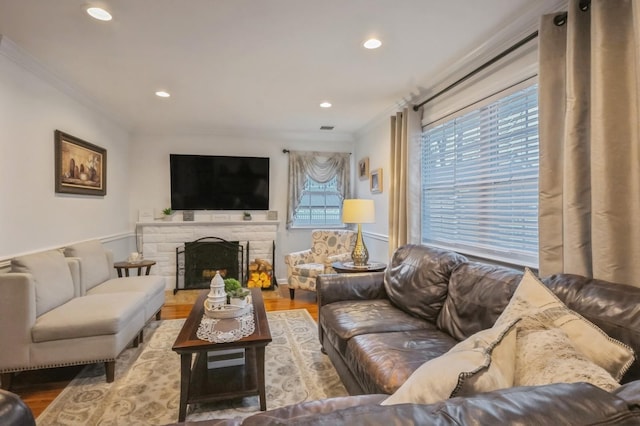 living room featuring crown molding, hardwood / wood-style floors, and a fireplace