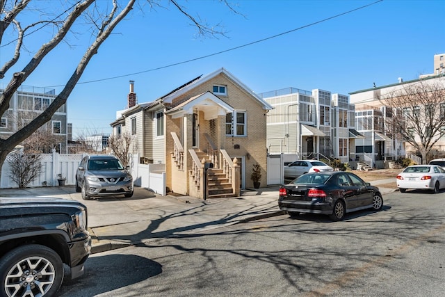 exterior space with brick siding, fence, and a residential view