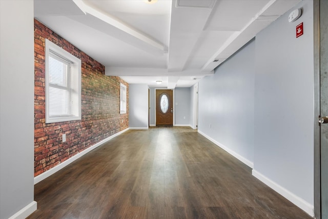 entryway featuring wood finished floors, baseboards, and brick wall