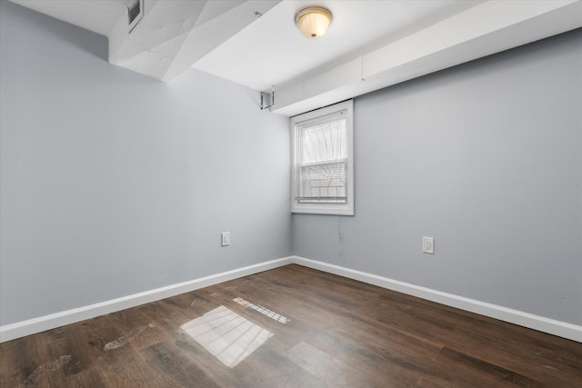 spare room with visible vents, wood finished floors, and baseboards