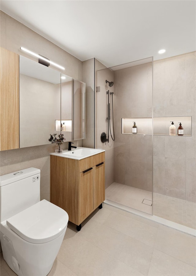 bathroom featuring vanity, tiled shower, and toilet