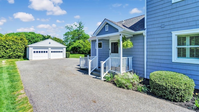 view of front of home featuring a garage and an outbuilding