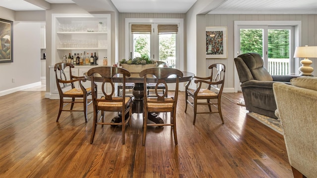 dining space featuring bar and dark hardwood / wood-style floors