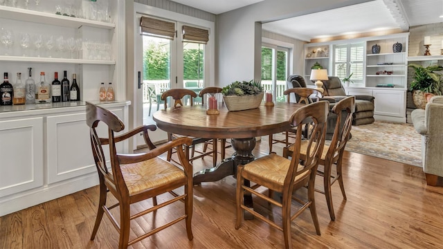 dining area featuring bar and light wood-type flooring