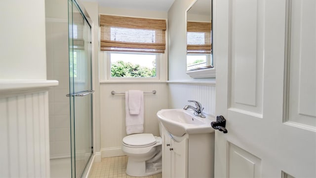 bathroom featuring vanity, tile patterned flooring, toilet, and walk in shower