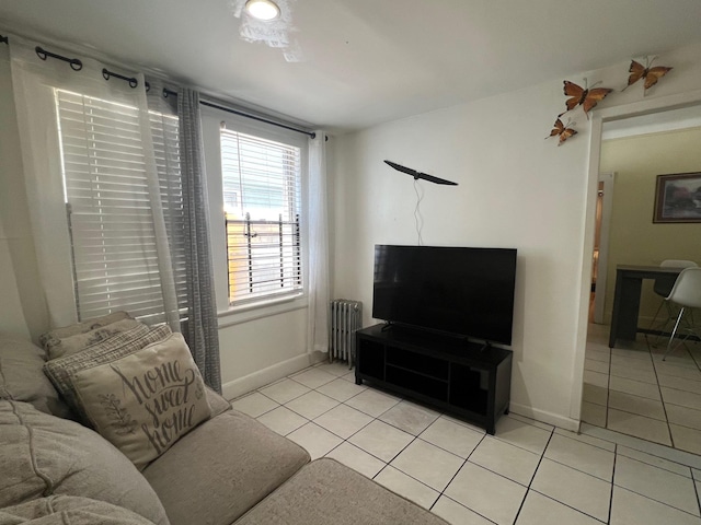 living area with radiator, baseboards, and light tile patterned flooring