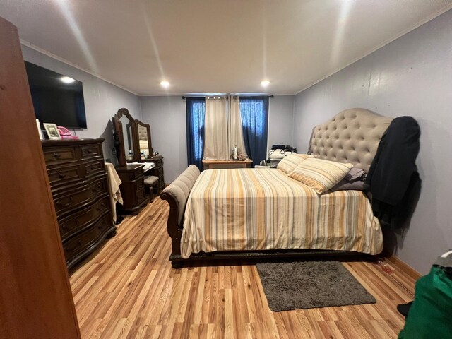 bedroom with light wood-type flooring and ornamental molding