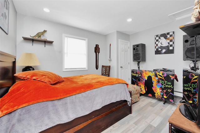 bedroom featuring a baseboard radiator and light hardwood / wood-style floors