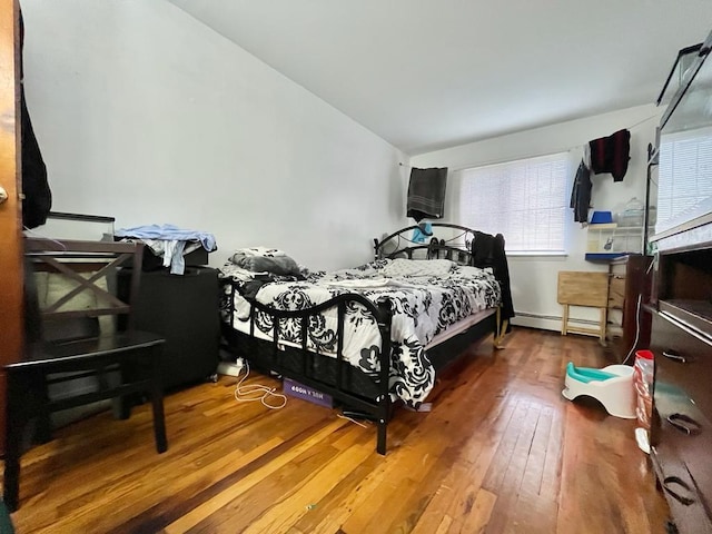 bedroom featuring wood-type flooring, lofted ceiling, and baseboard heating