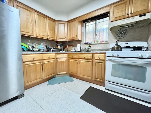 kitchen with stainless steel fridge, white gas range, and backsplash