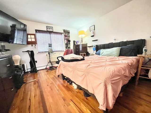 bedroom with wood-type flooring and baseboard heating