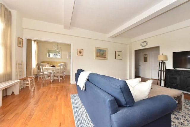 living area featuring light wood-type flooring and beamed ceiling