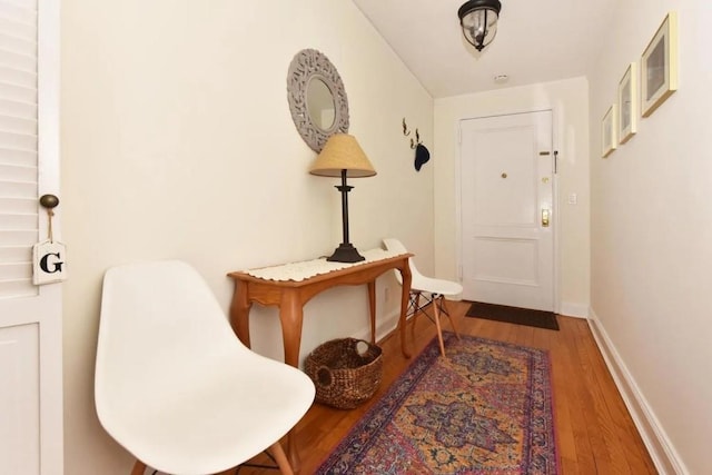 doorway with baseboards and wood finished floors