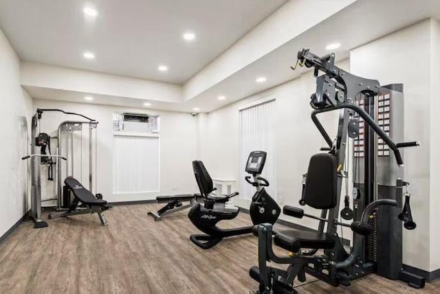 exercise room with baseboards, wood finished floors, and recessed lighting