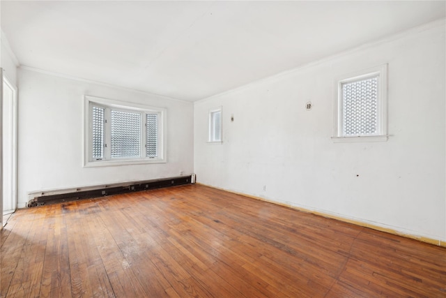 spare room featuring crown molding, hardwood / wood-style floors, and baseboard heating