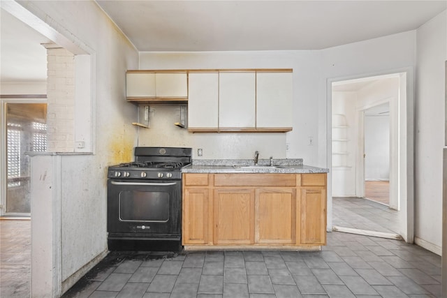 kitchen featuring sink, gas stove, decorative columns, and light brown cabinets