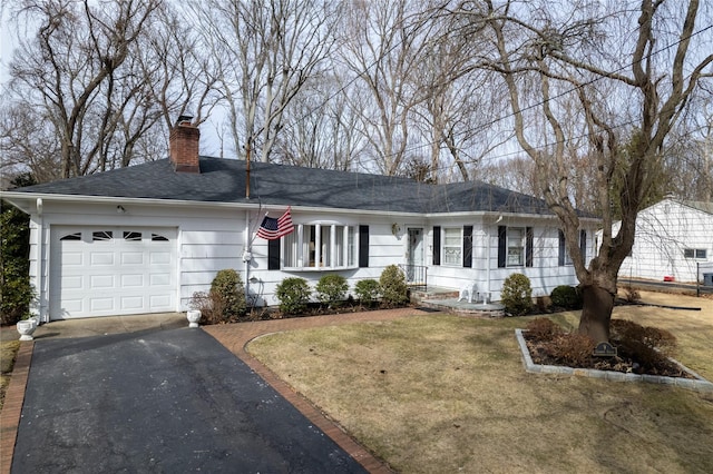 ranch-style home featuring a garage and a front lawn