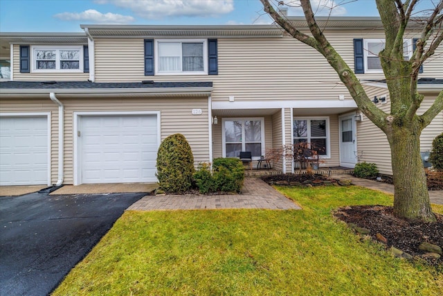 townhome / multi-family property featuring a garage and a front yard