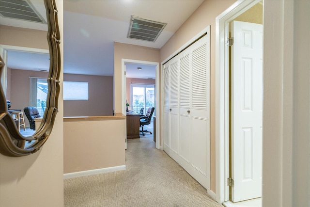 hall with baseboards, visible vents, and carpet