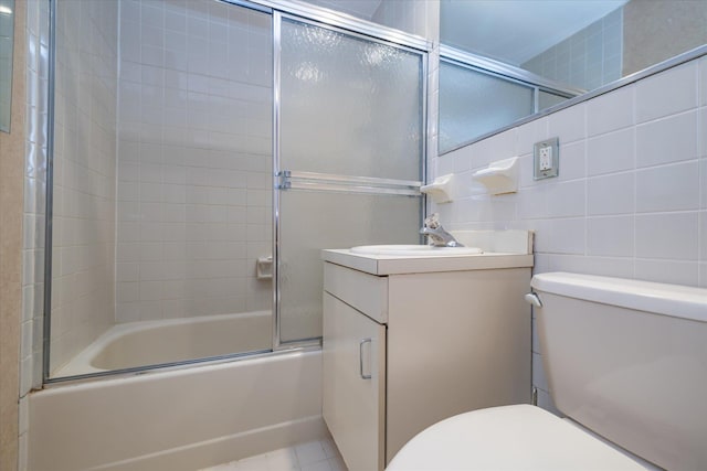 bathroom featuring vanity, bath / shower combo with glass door, tile patterned floors, and toilet