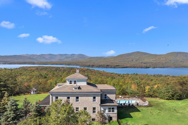 birds eye view of property featuring a wooded view and a water and mountain view