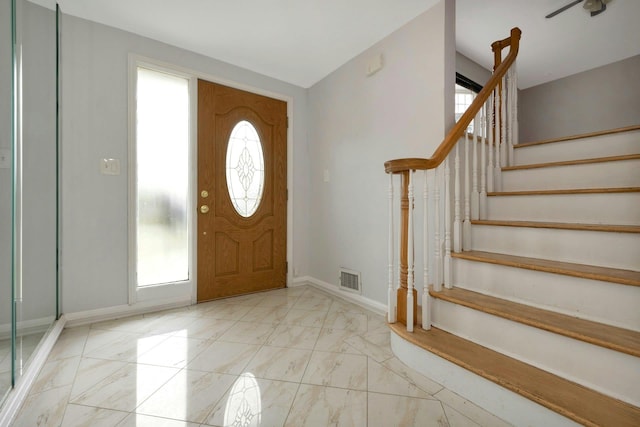 entrance foyer with a wealth of natural light, visible vents, stairway, and baseboards