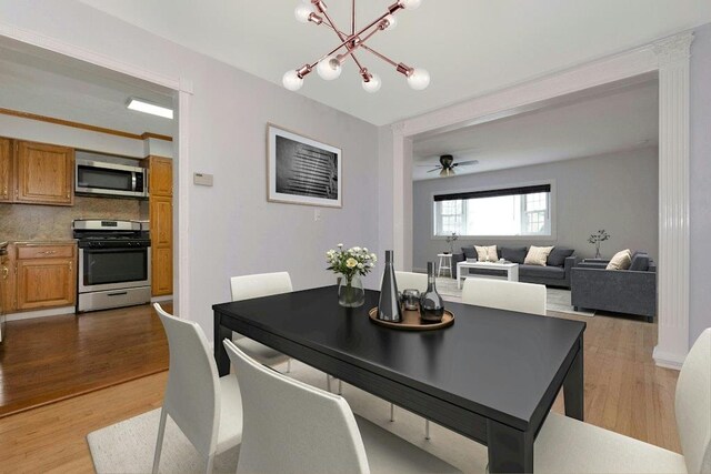 dining space with light wood-style flooring and ceiling fan with notable chandelier