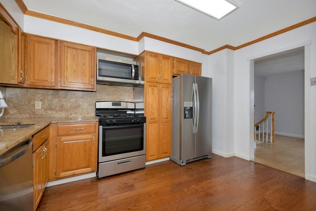 kitchen with appliances with stainless steel finishes, brown cabinetry, and dark wood-style floors