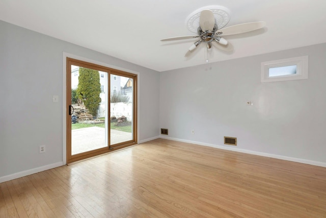 empty room with light wood-style flooring, a ceiling fan, visible vents, and baseboards