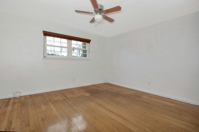 spare room with hardwood / wood-style flooring, baseboards, and a ceiling fan