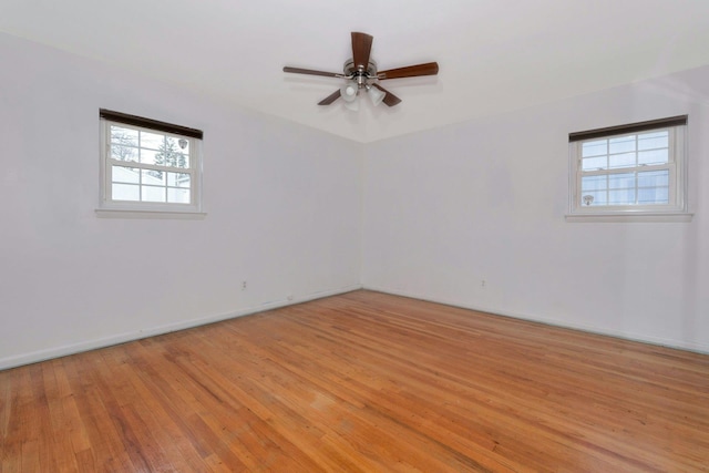 spare room with light wood-style floors, ceiling fan, and baseboards