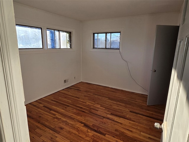 unfurnished room featuring dark wood-type flooring and plenty of natural light