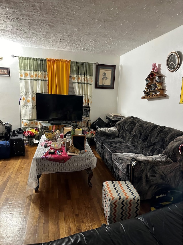 living area with hardwood / wood-style floors and a textured ceiling