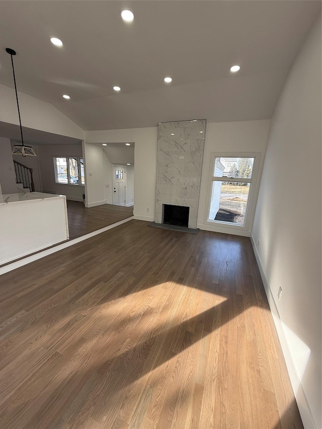 unfurnished living room with hardwood / wood-style flooring, lofted ceiling, and a premium fireplace