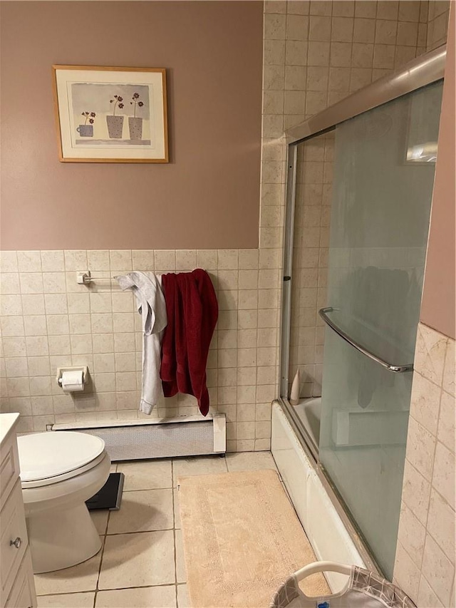 full bathroom featuring tile patterned flooring, vanity, combined bath / shower with glass door, and tile walls