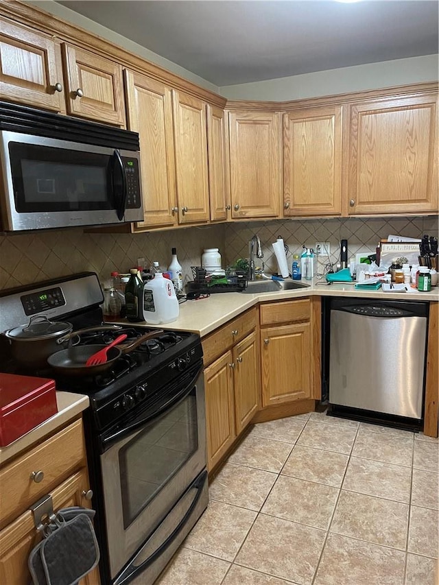 kitchen featuring sink, backsplash, stainless steel appliances, and light tile patterned flooring