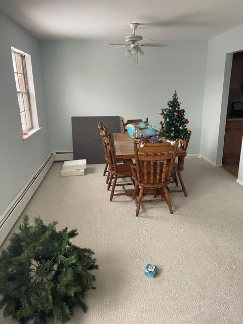 dining area with carpet floors, a baseboard heating unit, and ceiling fan