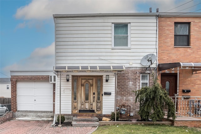 view of front of home featuring decorative driveway, brick siding, and an attached garage