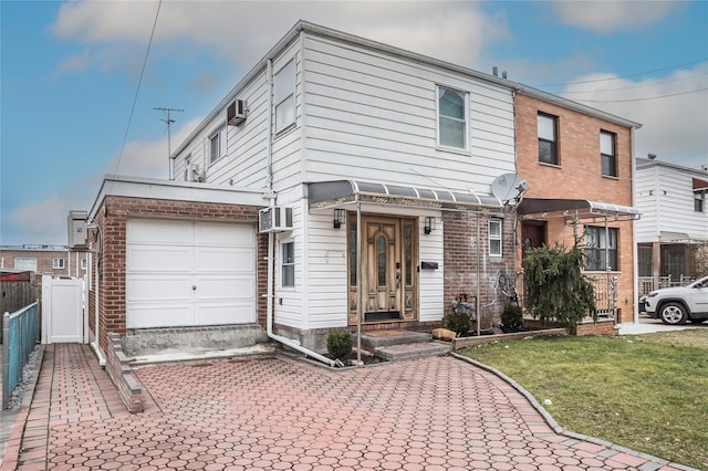 view of front of property with brick siding, an attached garage, fence, a front lawn, and a wall mounted AC